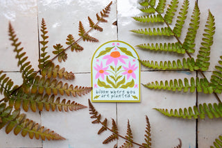 Decorative sticker with floral design and text that says bloom where you are planted