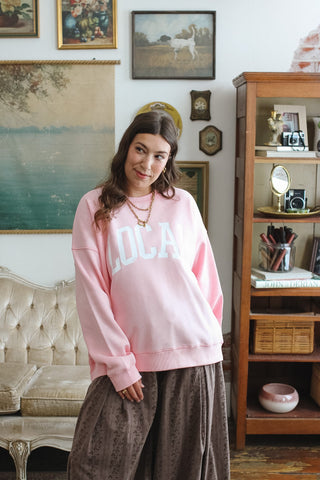 Woman wearing light pink classic crewneck sweatshirt