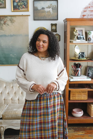 Woman wearing ivory and brown contrast stitch knit sweater