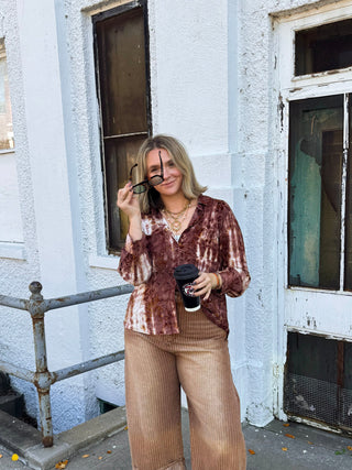 Woman wearing the Joanie floral velvet burnout button down in dusty mauve tie-dye with chest pockets, styled with wide leg jeans