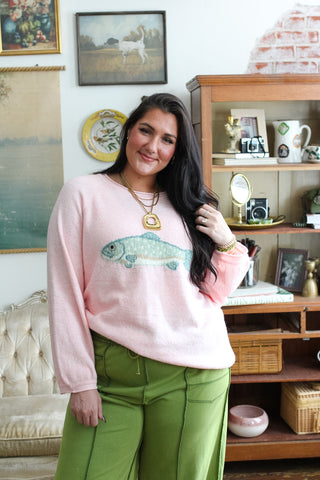 Woman wearing pink fish graphic roll neck sweater