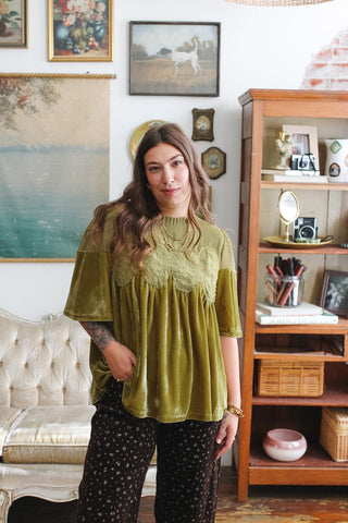 Woman wearing olive green velvet lace babydoll top