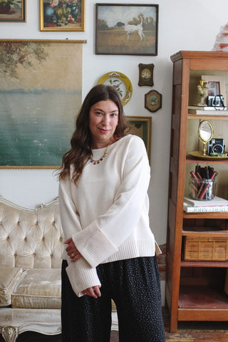 Woman wearing ecru sweater with ribbed cuffs