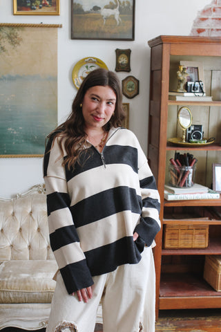 Woman wearing black and cream striped quarter zip sweater