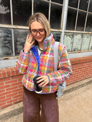 Woman wearing the Gia rainbow vintage plaid quilted jacket with a blue satin lining and brown corduroy pants