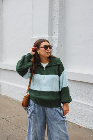 Woman wearing emerald and blue striped chunky knit quarter zip
