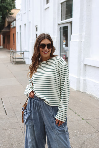 Woman wearing ivory and green striped long sleeve top