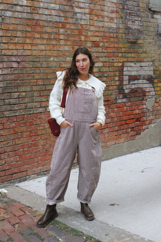 Woman wearing cherry brown striped barrel overalls
