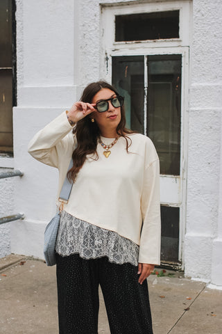 Woman wearing ivory long sleeve tee with lace hem
