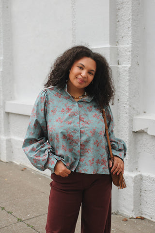 Woman wearing dusty blue floral button down blouse