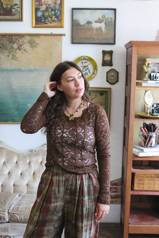 Woman wearing warm brown lace long sleeve top