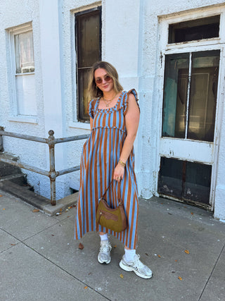 Woman wearing blue and brown striped babydoll midi dress