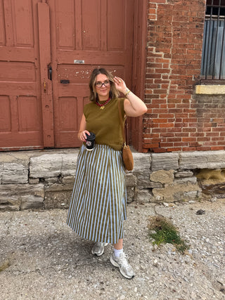 Woman wearing olive and blue striped midi skirt