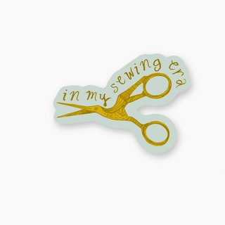 Sticker of a pair of scissors with in my sewing era text on it.