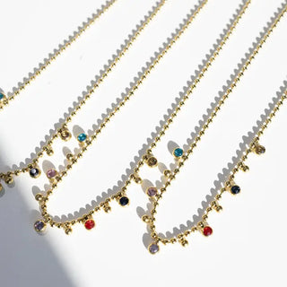 Gold necklaces with colorful beads on a white background